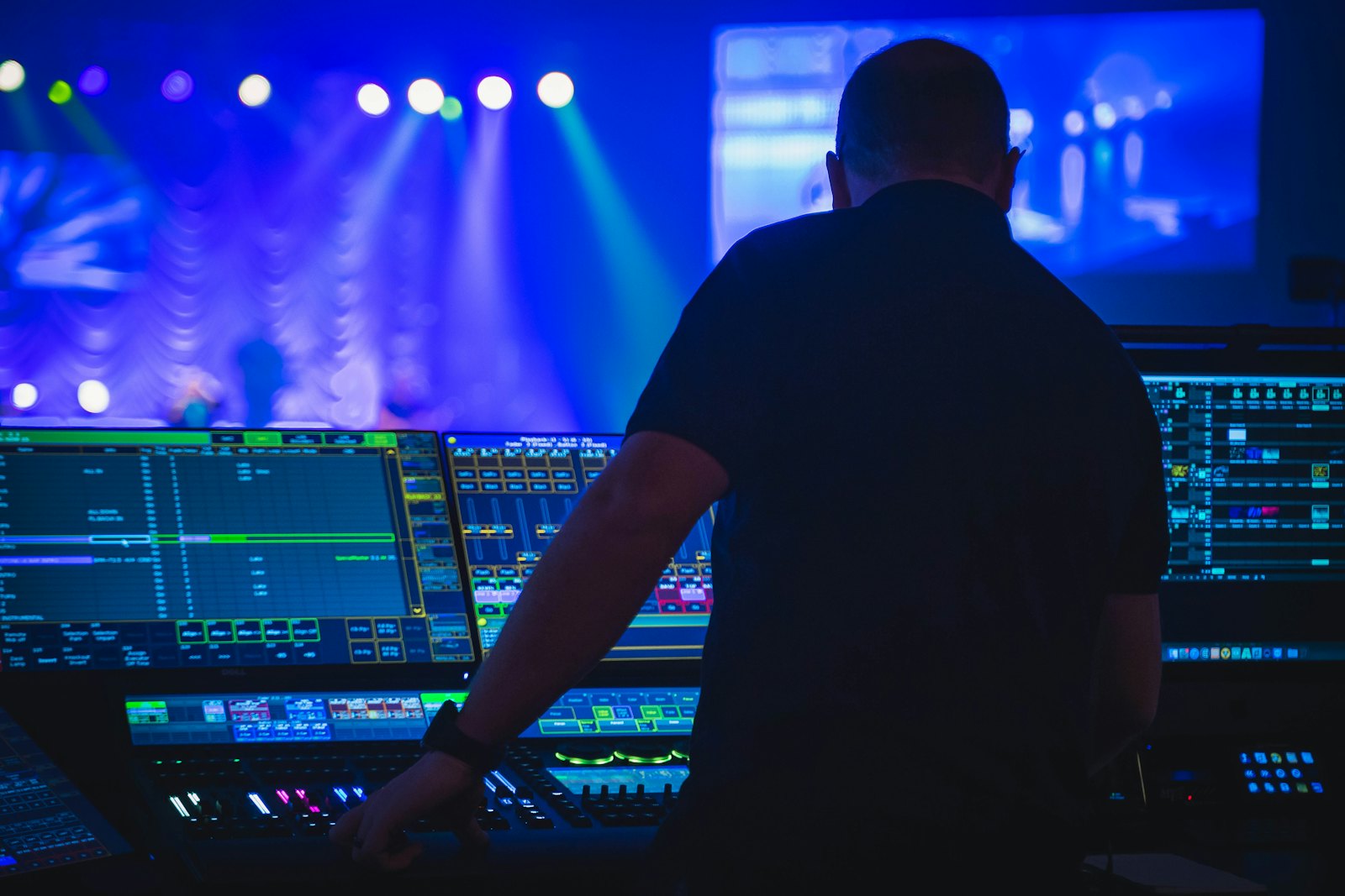 A technician running a lighting and sound control desk at a live event