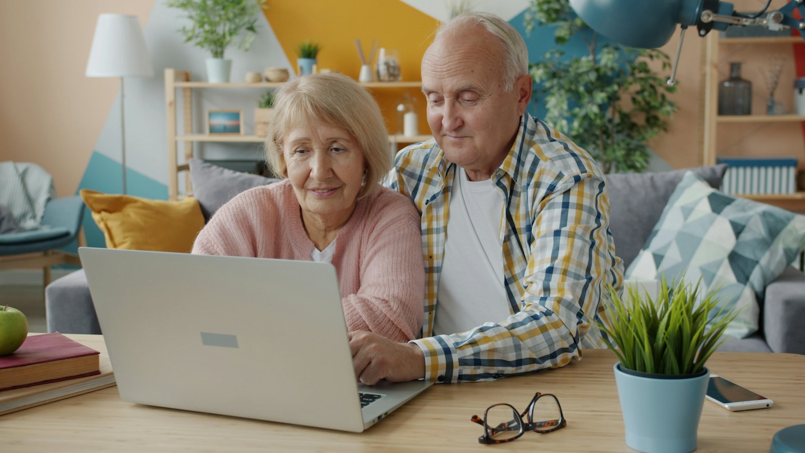 An older couple using a laptop together at home