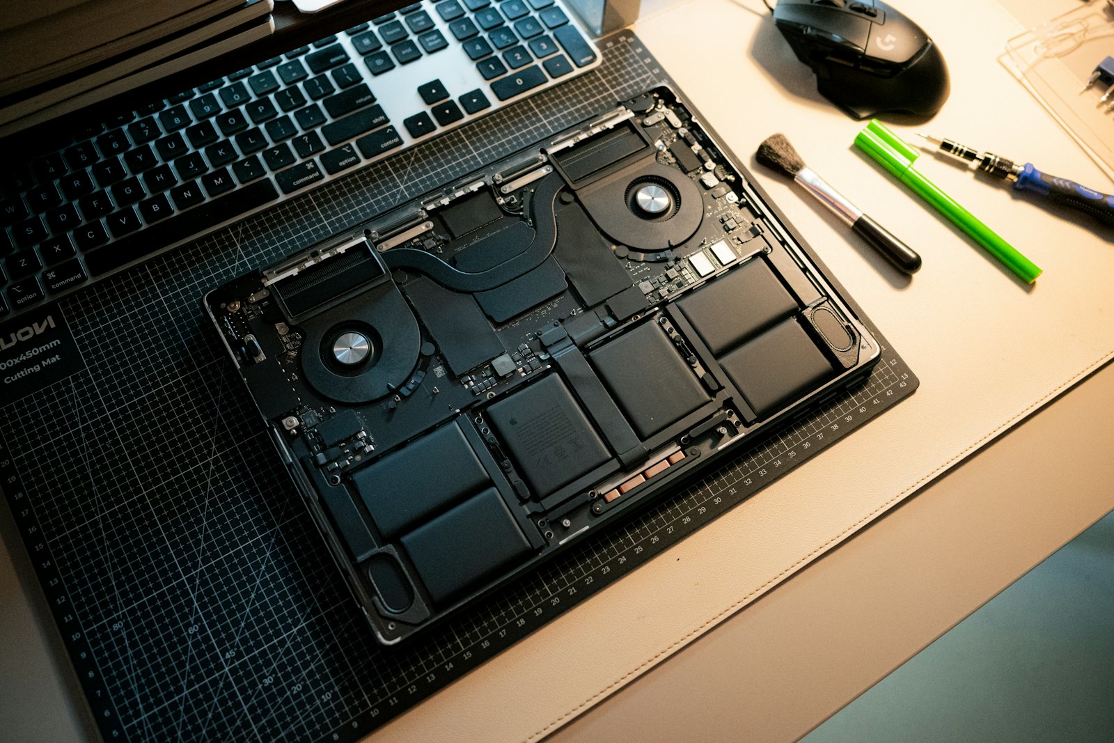 An open laptop with its internal components on a technician's workbench